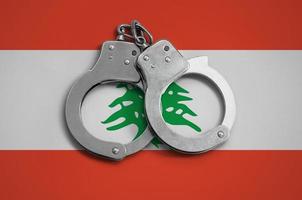 bandera libanesa y esposas policiales. el concepto de observancia de la ley en el país y protección contra el crimen foto