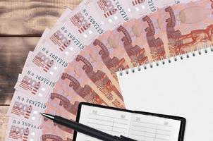 5000 russian rubles bills fan and notepad with contact book and black pen. Concept of financial planning and business strategy photo