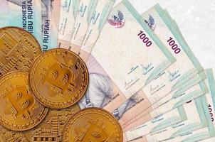 Billetes de 1000 rupias indonesias y bitcoins dorados. concepto de inversión en criptomonedas. criptominería o comercio foto