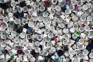 A pattern of many used and soiled nozzles from spray cans with aerosol paint. Background texture of the street art of drawing graffiti on the walls photo