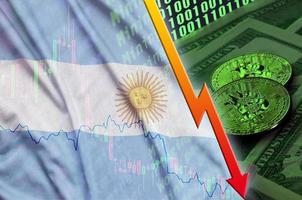 Argentina flag and cryptocurrency falling trend with two bitcoins on dollar bills and binary code display photo