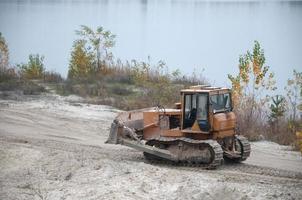 Quarry aggregate with heavy duty machinery. Caterpillar loader Excavator with backhoe driving to construction site quarry photo