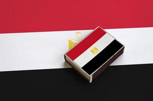 Egypt flag  is pictured on a matchbox that lies on a large flag photo