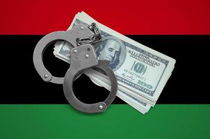 Libya flag  with handcuffs and a bundle of dollars. Currency corruption in the country. Financial crimes photo