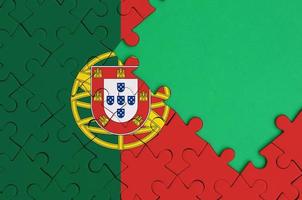 Portugal flag  is depicted on a completed jigsaw puzzle with free green copy space on the right side photo