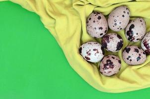 Quail eggs on a light green surface, top view, empty place for t photo