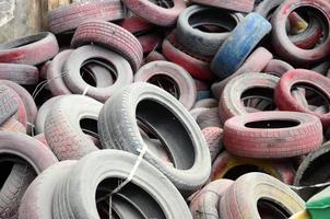 A picture of many old used tires left on a waste dump photo