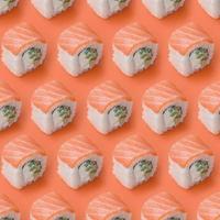 Philadelphia rolls with salmon on orange background. Minimalism top view flat lay pattern with Japanese food photo