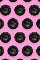 A few camera lenses with a closed aperture lie on texture background of fashion pastel pink color paper in minimal concept. Abstract trendy pattern photo