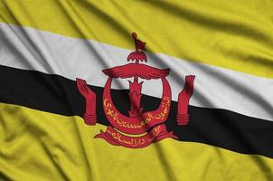 Brunei Darussalam flag  is depicted on a sports cloth fabric with many folds. Sport team banner photo