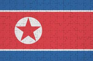 North Korea flag  is depicted on a folded puzzle photo