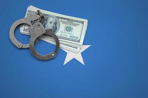 Somalia flag  with handcuffs and a bundle of dollars. The concept of breaking the law and thieves crimes photo