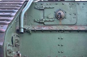 Texture of tank side wall, made of metal and reinforced with a multitude of bolts and rivets photo