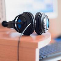 Big black headphones lie on the wooden desktop of the sound designer photo