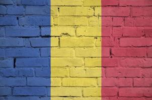 Romania flag is painted onto an old brick wall photo