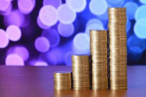 Golden coin stacks arranged as a graph. Increasing columns of coins photo