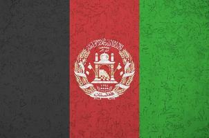 Afghanistan flag depicted in bright paint colors on old relief plastering wall. Textured banner on rough background photo