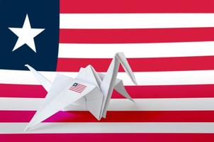 Liberia flag depicted on paper origami crane wing. Handmade arts concept photo