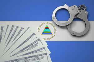 Nicaragua flag  with handcuffs and a bundle of dollars. The concept of illegal banking operations in US currency photo