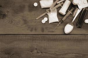 A lot of narcotic substances and devices for the preparation of drugs lie on an old wooden table photo
