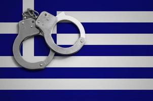 Greece flag  and police handcuffs. The concept of crime and offenses in the country photo