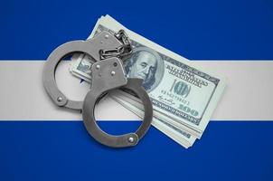 Honduras flag  with handcuffs and a bundle of dollars. Currency corruption in the country. Financial crimes photo