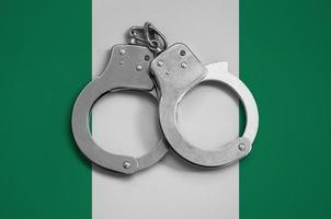 Nigeria flag  and police handcuffs. The concept of observance of the law in the country and protection from crime photo