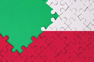 Poland flag  is depicted on a completed jigsaw puzzle with free green copy space on the left side photo