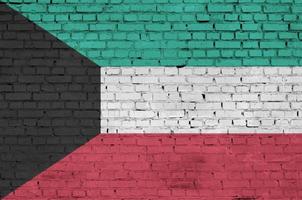 la bandera de kuwait está pintada en una vieja pared de ladrillos foto