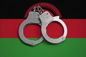 Malawi flag  and police handcuffs. The concept of observance of the law in the country and protection from crime photo