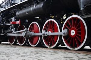 Red wheels of steam train photo