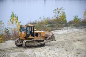 Quarry aggregate with heavy duty machinery. Caterpillar loader Excavator with backhoe driving to construction site quarry photo