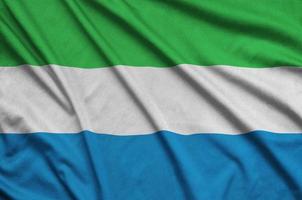 Sierra Leone flag  is depicted on a sports cloth fabric with many folds. Sport team banner photo