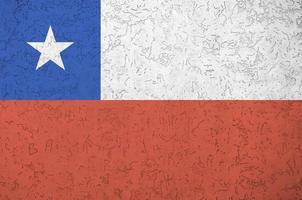 Chile flag depicted in bright paint colors on old relief plastering wall. Textured banner on rough background photo