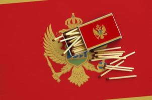 Montenegro flag  is shown on an open matchbox, from which several matches fall and lies on a large flag photo