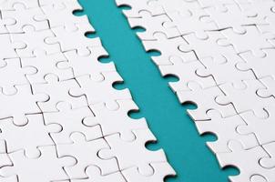 The blue path is laid on the platform of a white folded jigsaw puzzle. Texture image with copy space for text photo