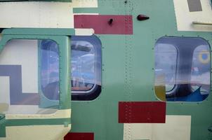 Helicopter cabin fragment close up. Camouflage aircraft fuselage and bulletproof glass photo