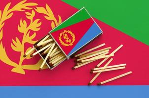Eritrea flag  is shown on an open matchbox, from which several matches fall and lies on a large flag photo