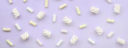 Colorful marshmallow laid out on violet paper background. pastel creative texture. minimal photo