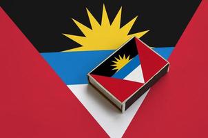 Antigua and Barbuda flag  is pictured on a matchbox that lies on a large flag photo