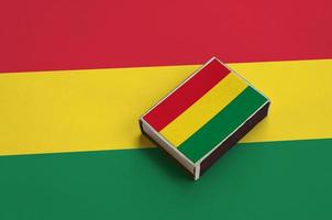 Bolivia flag  is pictured on a matchbox that lies on a large flag photo