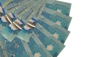 5 Canadian dollars bills lies isolated on white background with copy space stacked in fan shape close up photo