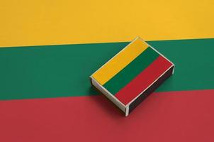 Lithuania flag  is pictured on a matchbox that lies on a large flag photo