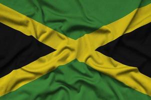 Jamaica flag  is depicted on a sports cloth fabric with many folds. Sport team banner photo