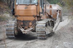 agregado de cantera con maquinaria pesada. Excavadora de oruga con retroexcavadora que conduce a la cantera del sitio de construcción foto