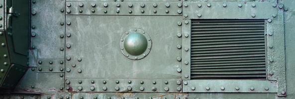 Texture of tank side wall, made of metal and reinforced with a multitude of bolts and rivets photo