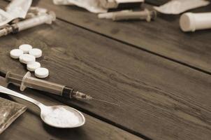 A lot of narcotic substances and devices for the preparation of drugs lie on an old wooden table photo