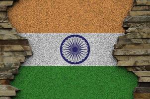 India flag depicted in paint colors on old stone wall closeup. Textured banner on rock wall background photo