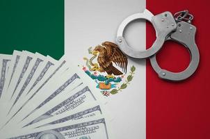 Mexico flag  with handcuffs and a bundle of dollars. The concept of illegal banking operations in US currency photo