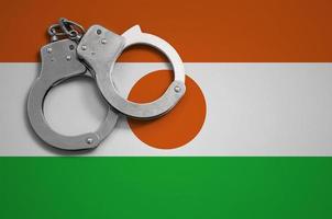 Niger flag  and police handcuffs. The concept of crime and offenses in the country photo